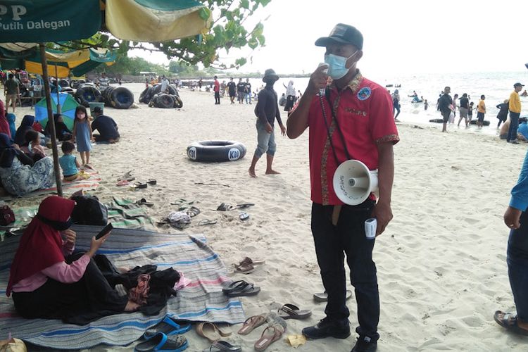 Petugas terus mengingatkan para pengunjung wisata pasir putih Dalegan untuk menerapkan protokol kesehatan.