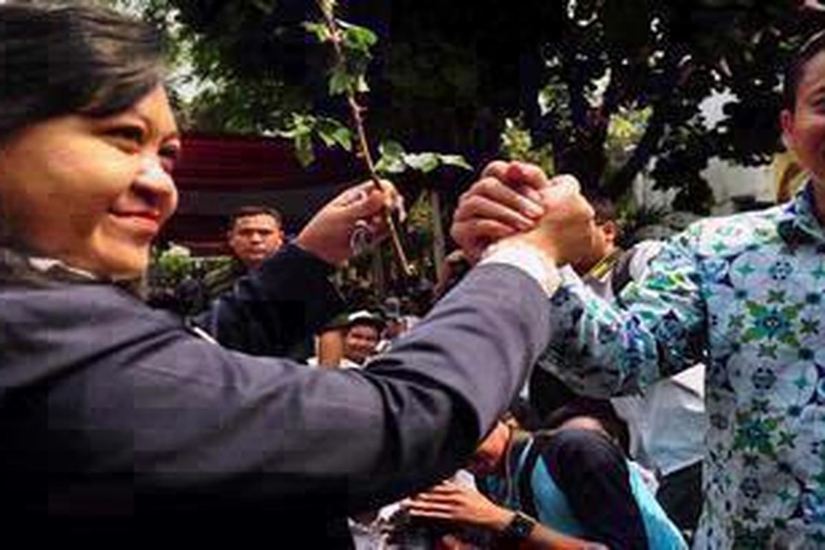 Kepala Sekolah SMA 6 Dra. Kadarwati Mardiutama, M.Si (kiri) menerima setangkai Mawar Putih dari Kepsek 70 Saksono Liliek Susanto (kanan) di SMA 70 Jakarta, Jakarta Selatan, Senin (1/10/2012). Dalam acara ini siswa SMAN 70 Jakarta melakukan aksi tabur bunga dan meletakan karangan bunga di Bundaran Bulungan.Acara ini juga bertujuan untuk perdamaian konflik antara SMA 6 dengan SMA 70 yang sudah bertikai sejak lama.