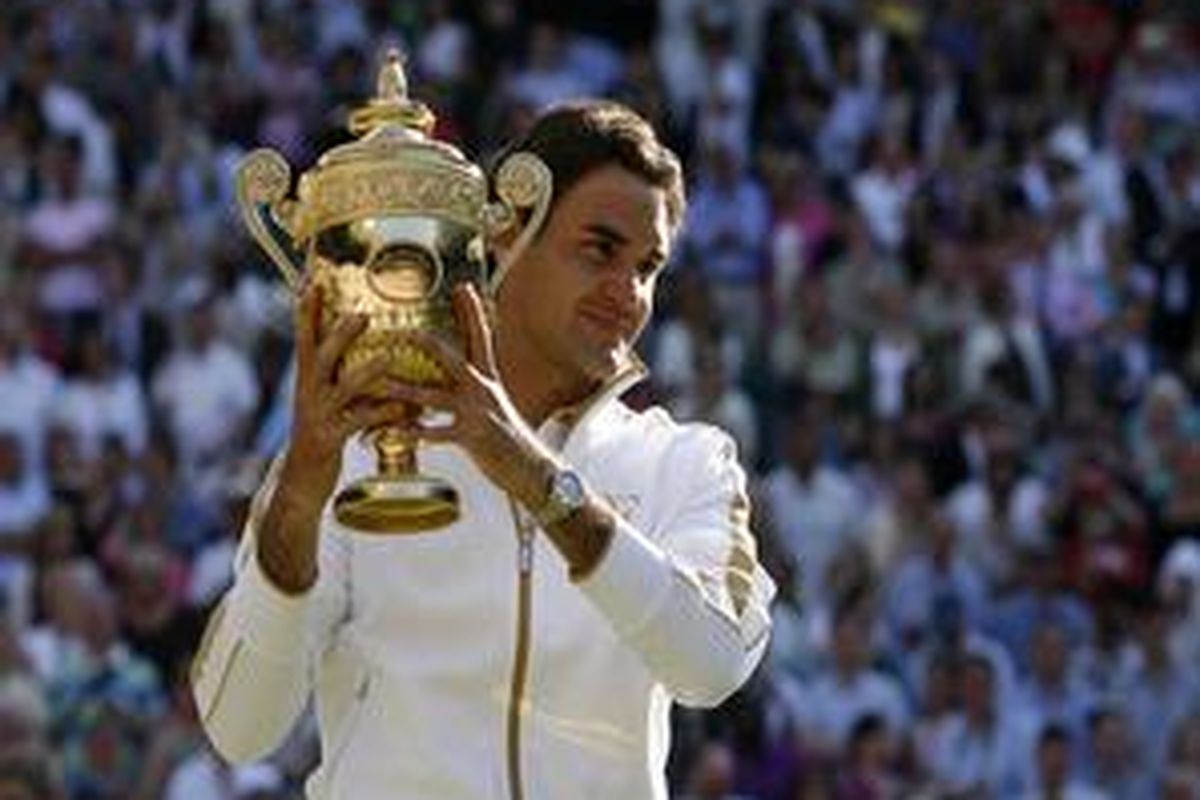 Roger Federer mengangkat trofi Wimbledon. Dia juga merupakan juara bertahan AS Terbuka.
