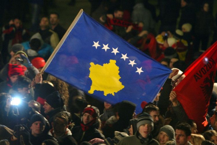 Seorang warga membentangkan bendera Kosovo pasca-pernyataan deklarasi kemerdekaan dari Serbia pada 17 Februari 2008.