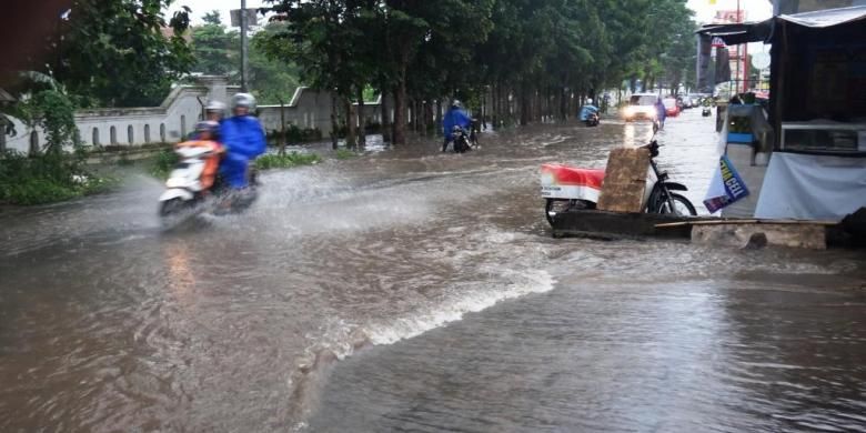 Pengendara roda dua di Jalan Mastrip, Kabupaten Jember, Jawa Timur, yang memaksa menerobos banjir, akhirnya motornya mogok, Jumat (6/3/2015).