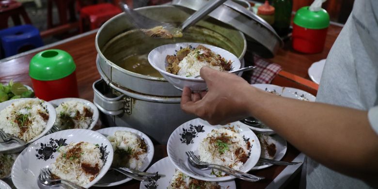 Penyajian rawon dan soto yang disiram kuah kaldu panas yang sudah bercampur rempah, di Rawon Kalkulator, Surabaya.