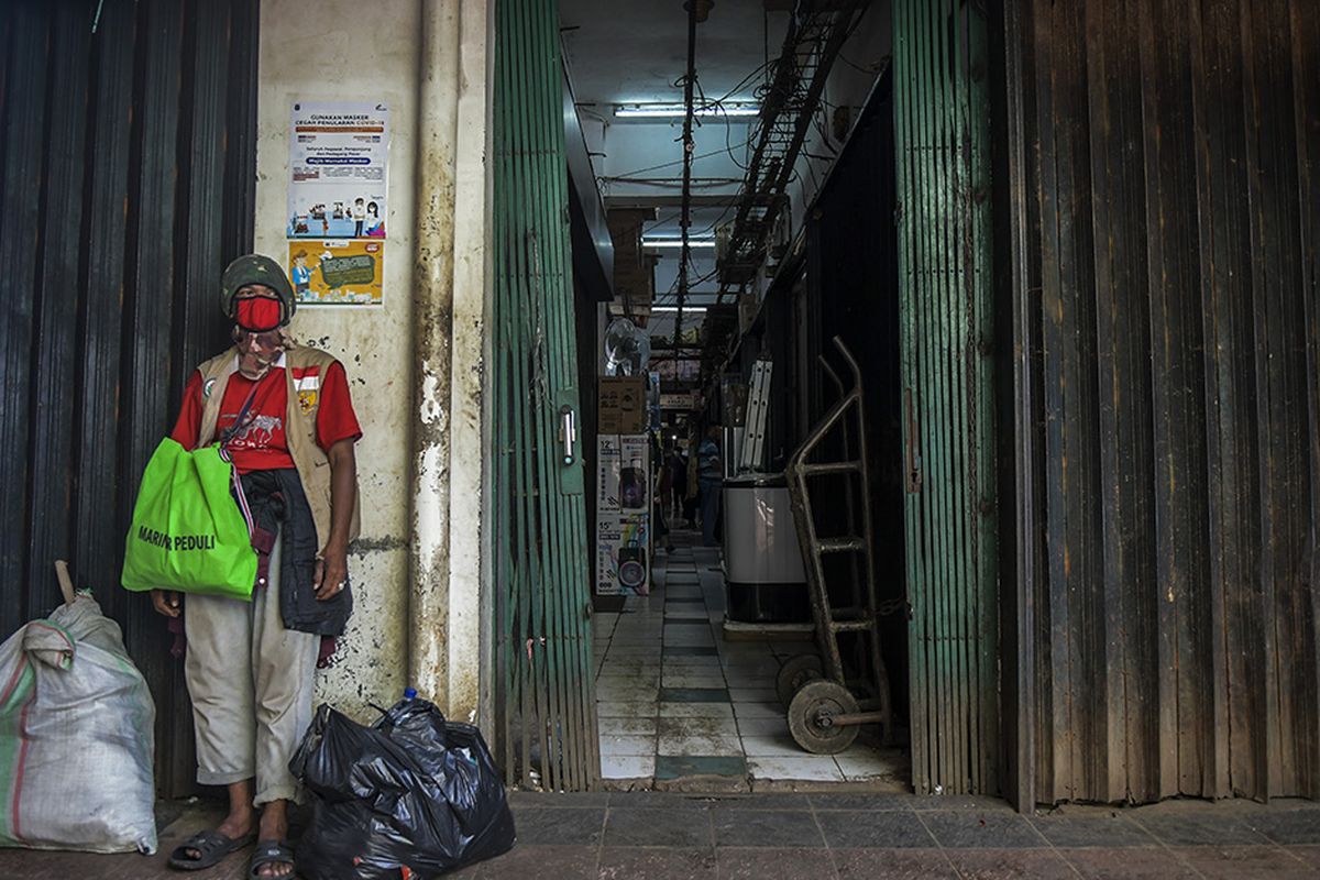 Foto dirilis Kamis (28/4/2020), menunjukkan seorang laki-laki mengenakan masker dan berdiri di depan toko yang tutup akibat merebaknya wabah COVID-19 di Pasar Minggu, Jakarta. Imbas wabah Covid-19, gejolak pada aspek kesehatan turut merembet ke sektor ekonomi dengan sebagian besar aktivitas ekonomi di Tanah Air terhenti.