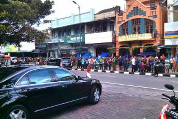 Para wisatawan lambaikan tangan ketika presiden Joko Widodo melintas di jalan malioboro meninggalkan hotel Inna Garuda