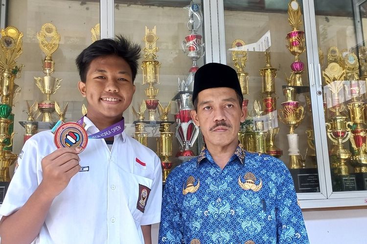 Sidiq Khoerulsyah (16) siswa SMAN 1 Tasikmalaya menunjukkan medali juara ketiga kejuaraan dunia Taekwondo di Korea Selatan di sekolahnya pada Senin (18/7/2022).