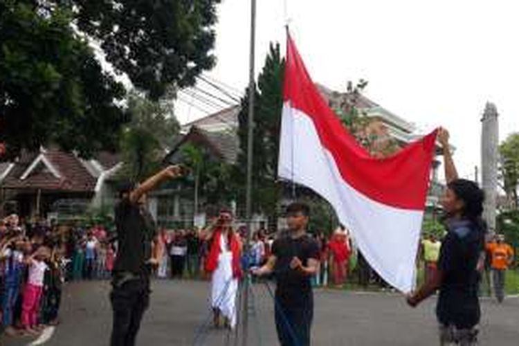 Muhammad Bardha Sadeli (kanan) saat mengibarkan bendera merah putih dalam upacara HUT Kemerdekaan RI bagi anak jalanan di Jalan Blitar Kota Malang, Rabu (17/8/2016)