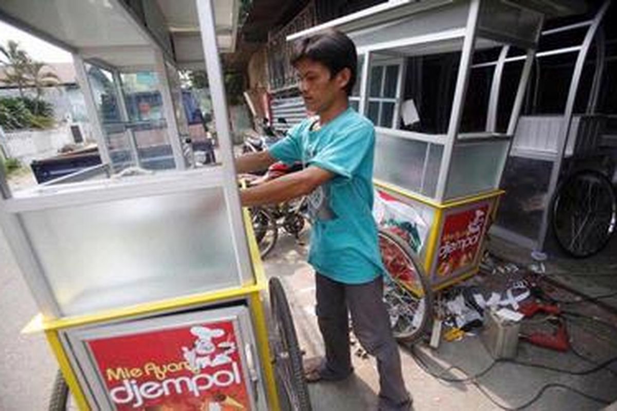 Seorang pekerja tengah menyelesaikan pembuatan gerobak pesanan di bengkel produksi TN Alumunium di kawasan Pondok Bambu, Jakarta Timur, Kamis (29/9/2011). Gerobak warlaba ternyata tidak hanya dijual ke berbagai kota di Indonesia, tetapi juga diekspor ke Malaysia, Thailand, bahkan Amerika Serikat.   