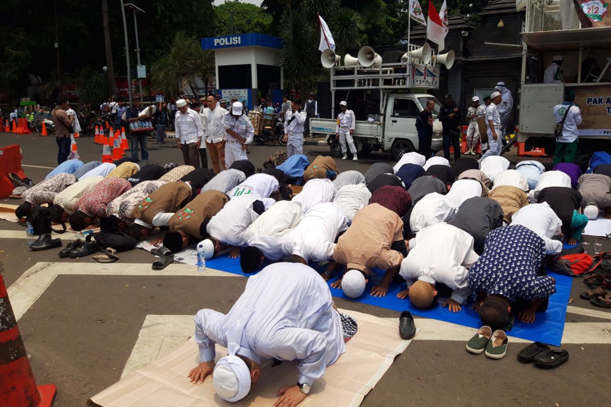 Massa pengawal Amien Rais shalat zuhur di depan PMJ, Jakarta Selatan, Rabu (10/10/2018). 