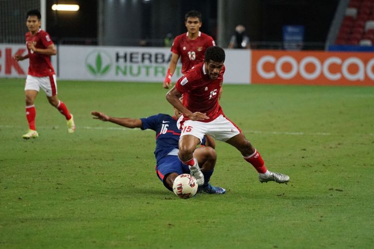 Gelandang timnas Indonesia Ricky Kambuaya mendapat tekel dari pemain Singapura Hami Syahin pada laga leg kedua semifinal Piala AFF 2020 di Stadion Nasional, Singapura, pada Sabtu (25/12/2021).
