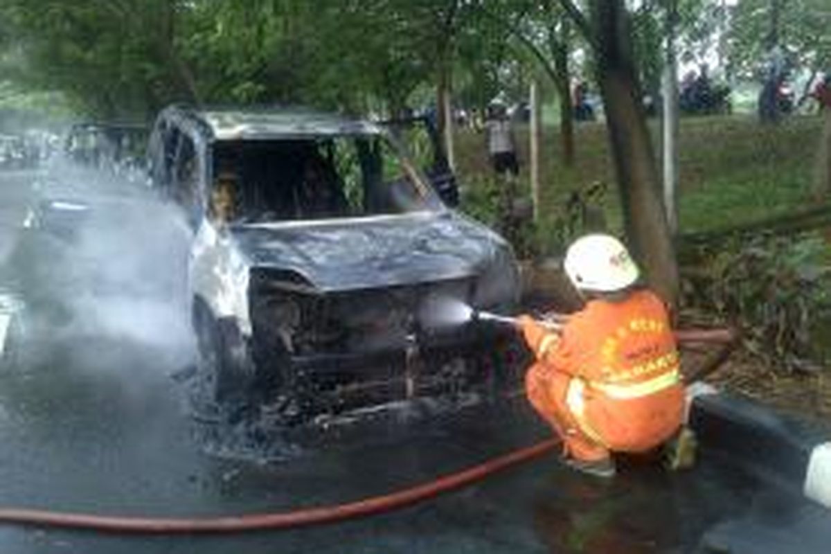 Sebuah mobil Nissan X Trail berwarna hitam terbakar di kawasan Duren Sawit, Jakarta Timur. Selasa (15/7/2014)
