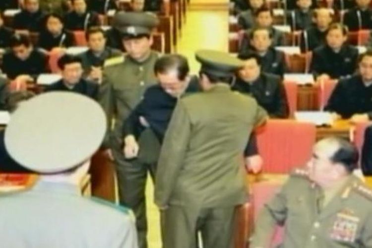 Foto yang diambil dari kantor berita Korea Utara KCNA ini menampilkan saat-saat paman Kim Jong Un, Jang Song Thaek diseret dua petugas dari kursinya di tengah-tengah sebuah rapat penting partai.