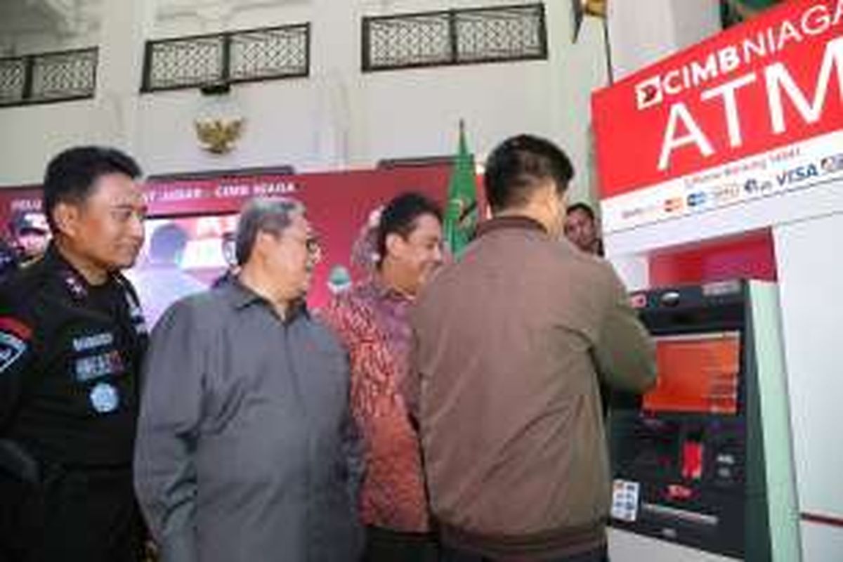 Gubernur Jawa Barat Ahmad Heryawan (kedua dari kiri) bersama Kapolda Jawa Barat Irjen Pol. Bambang Waskito (kiri), dan Head of Digital Banking, Branchless and Partnership CIMB Niaga Bambang Karsono Adi (kedua dari kanan) menyaksikan nasabah melakukan pembayaran pajak kendaraan bermotor (PKB) melalui ATM CIMB Niaga.