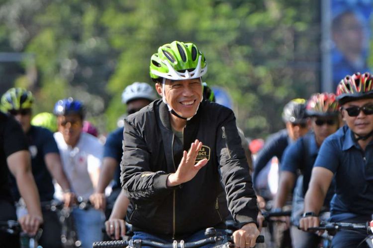 Presiden RI Joko Widodo bersepeda saat menuju ke lokasi pembagian sertifikat sambungan listrik gratis kepada 100 rumah tangga miskin dan rentan miskin di Bogor, Jawa Barat (2/12/2018). Sebelumnya Presiden berkesempatan mengisikan token dan menyalakan listrik 5 (lima) rumah tangga di Bantarjati, Bogor.