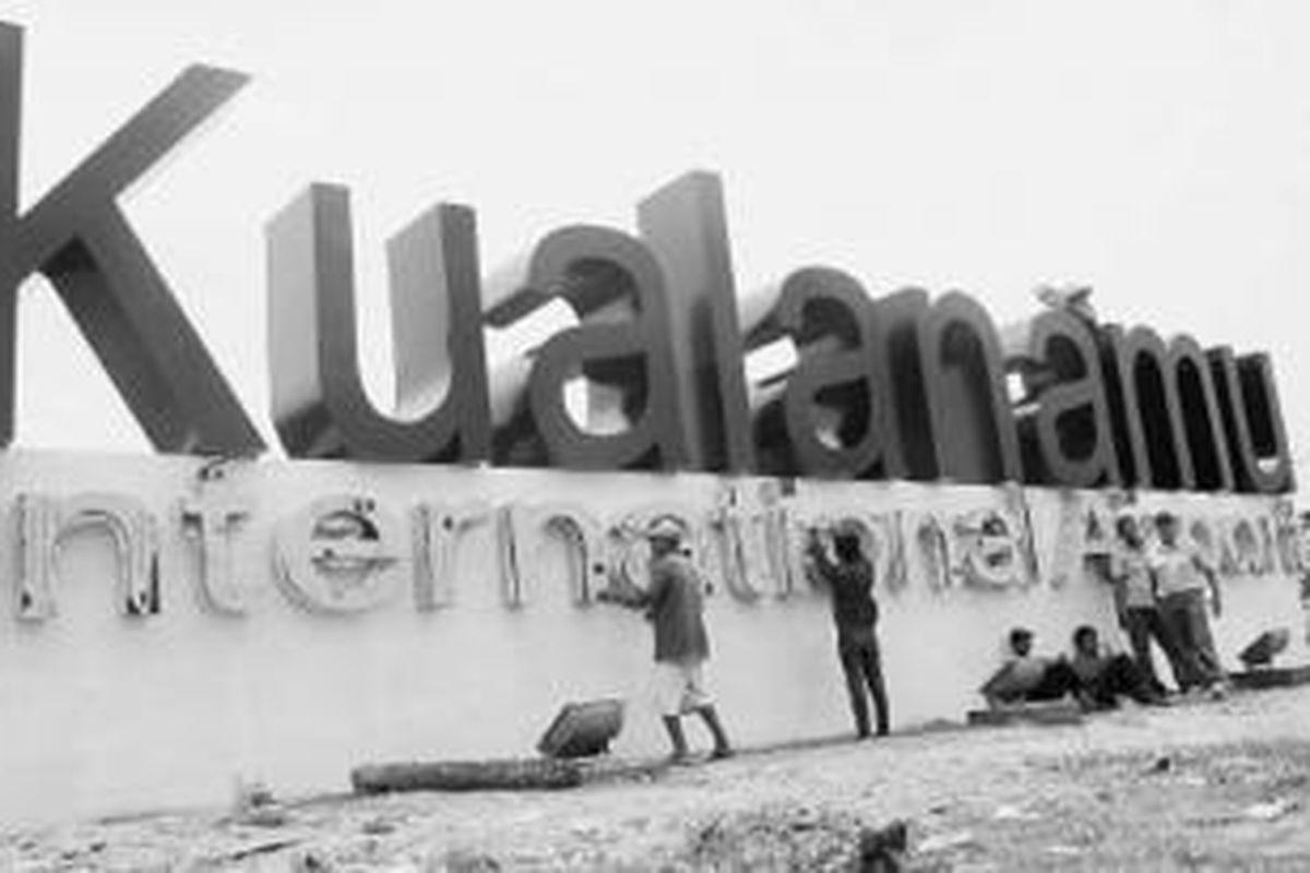 Sejumlah pekerja menyelesaikan pembuatan nama Bandar Udara Internasional Kualanamu di Deli Serdang, Sumatera Utara, Selasa (23/7/2013). Para pekerja mengebut berbagai pekerjaan yang belum tuntas karena bandara itu akan dibuka pada Kamis (25/7/2013).