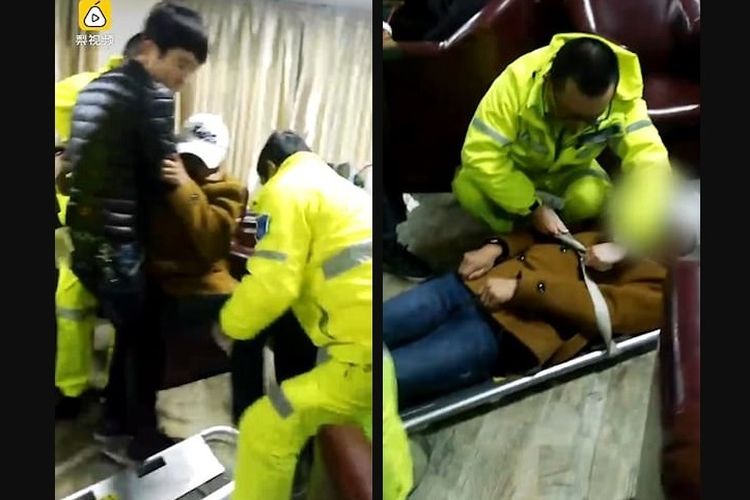 Remaja yang lumpuh setelah bermain game selama lebih dari 20 jam tengah diangkat dari kursi oleh teman dibantu paramedis dan dipindahkan ke papan tandu sebelum dibawa ke rumah sakit.