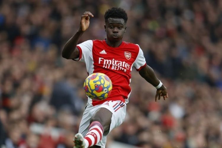 Penyerang sayap Arsenal, Bukayo Saka, mengontrol bola dalam pertandingan Liga Inggris melawan Brentford di Stadion Emirates, London, 19 Februari 2022. Terdekat, Bukayo Saka bersama Arsenal akan menghadapi Man United pada laga pekan ke-21 Liga Inggris, Minggu (23/1/2023). Link live streaming Arsenal vs Man United tersedia di akhir artikel ini.