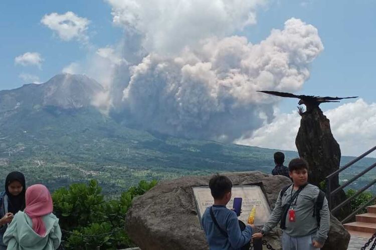 Some tourists at a tourism attraction in Ketep Pass in Magelang regency, Central Java are watching Indonesia's Mount Merapi, one of the world's most active volcanoes, which erupts on Saturday, March 11, 2023. 