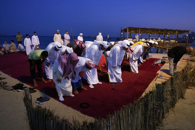 Para jemaah sedang shalat di Pantai Katara di Doha, Qatar, Senin, 28 November 2022. Hingga 1 juta pengunjung datang ke Qatar selama Piala Dunia. Bagi banyak orang, ini adalah kunjungan pertama mereka ke negara Muslim.