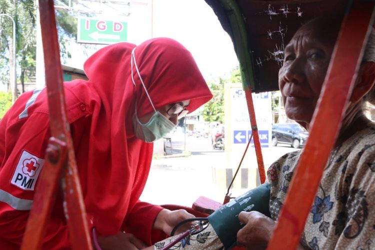 Relawan PMI Surakarta melekukan pengecekan kesehatan terhadap tukang becak di Solo, Jawa Tengah.