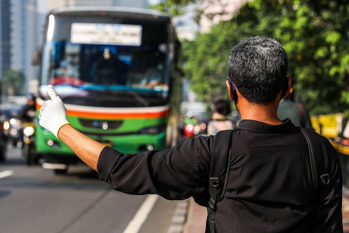 Pekerja kantoran saat menunggu kendaraan umum di Jalan M.H. Thamrin, Jakarta Pusat, Senin (8/6/2020). Pemprov DKI Jakarta mengizinkan perkantoran kembali beroperasi sejak hari ini, namun dengan penerapan protokol kesehatan.