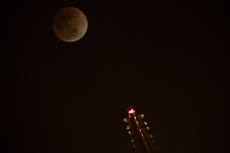 Penampakan bulan saat terjadinya gerhana bulan total atau super blue blood moon, di atas Tokyo Tower, Tokyo, Rabu (31/1/2018) malam. Warga di berbagai belahan dunia antusias menyaksikan fenomena langka yang terjadi bertepatan saat bulan berada dalam konfigurasi supermoon dan blue moon ini terjadi sekitar dalam kurun waktu 150 tahun sekali.