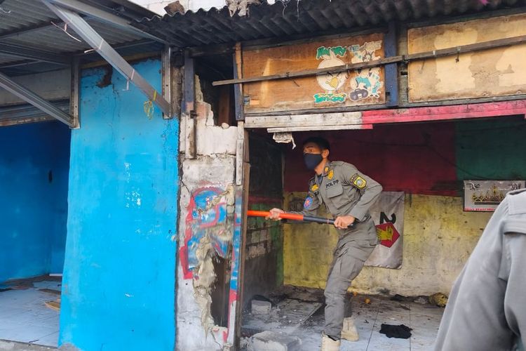 Seorang anggota Satpol-PP membongkar salah satu bangunan milik organisasi masyarakat (Ormas) di kawasan Cibinong Raya, Kabupaten Bogor, Jawa Barat, Selasa (26/8/2025).