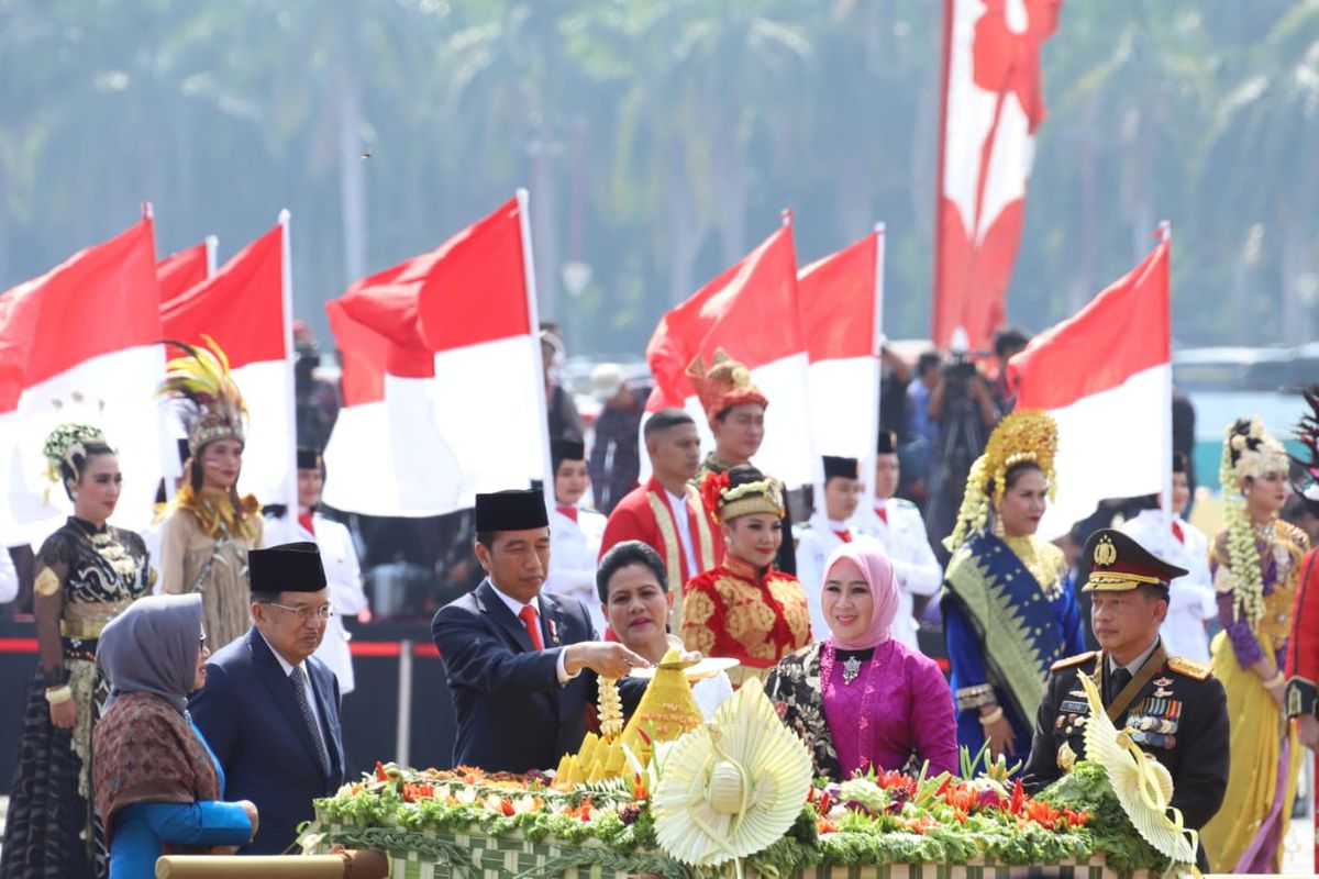 Presiden Joko Widodo didampingi ibu Iriana, sedang memotong tupeng dalam Upacara Peringatan Bhayangkara ke-73 di Silang Monas, Jakarta, Rabu (10/7/2019). Hadir pula dalam pemotongan itu Wakil Presiden Jusuf Kalla bersama istri dan Kapolri Jenderal Tito Karnavian bersama istri. 