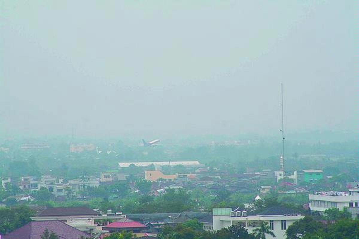 Kabut asap menyelimuti Kota Medan dan sekitarnya, Selasa (26/2). Menurut BMG Polonia, keadaan ini cukup mengganggu penerbangan pesawat kecil. Kabut yang cukup rendah menyelimuti perbukitan dan pegunungan di kawasan pesisir timur Sumut bisa sangat mengganggu manuver dan penerbangan pesawat kecil. Tampak sebuah pesawat baru saja lepas landas dari Bandara Polonia.  
