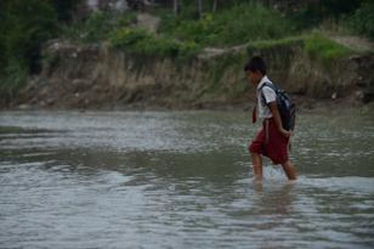 Siswa menyeberangi sungai untuk kembali ke rumah setelah masuk sekolah pada hari pertama di Desa Jragung, Kecamatan Karangawen, Kabupaten Demak, Jawa Tengah, Senin (15/7/2013)