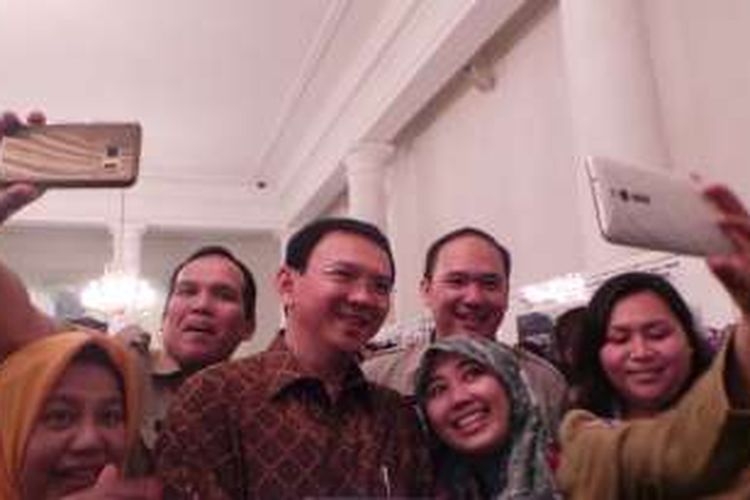 Gubernur DKI Jakarta Basuki Tjahaja Purnama berselfie dengan pegawai negeri sipil (PNS) DKI Jakarta, di Balai Kota DKI Jakarta, Senin (11/7/2016).