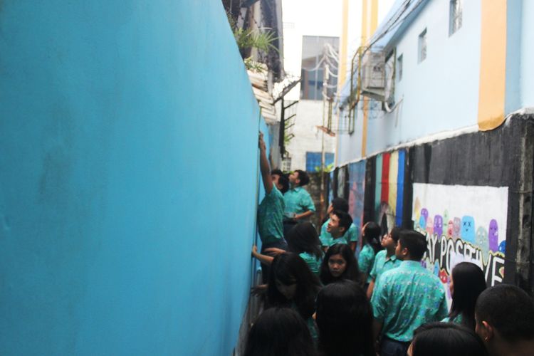 Pelajar sekolah Kristen Kanaan Cianjur, Jawa Barat tengah melukis dinding tembok gang di belakang sekolah mereka untuk menyulap gang kumuh menjadi spot instagenic lewat seni mural