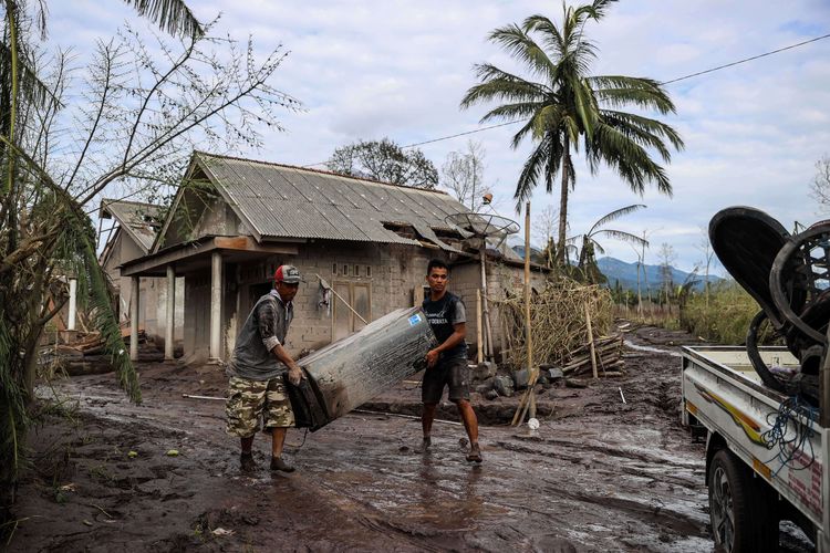 Warga saat menyelamatkan barang dari rumah mereka yang terdampak erupsi Gunung Semeru yang meluncurkan awan panas di Desa Curah Kobokan, Kecamatan Candipuro, Lumajang, Jawa Timur, Selasa (7/12/2021). Berdasarkan data Badan Nasional Penanggulangan Bencana (BNPB) per Senin (06/12) pukul 20.15 WIB, setidaknya 22 orang tewas, sementara 22 orang dinyatakan hilang dan 56 lainnya mengalami luka-luka. Erupsi juga berdampak terhadap 5.205 jiwa.