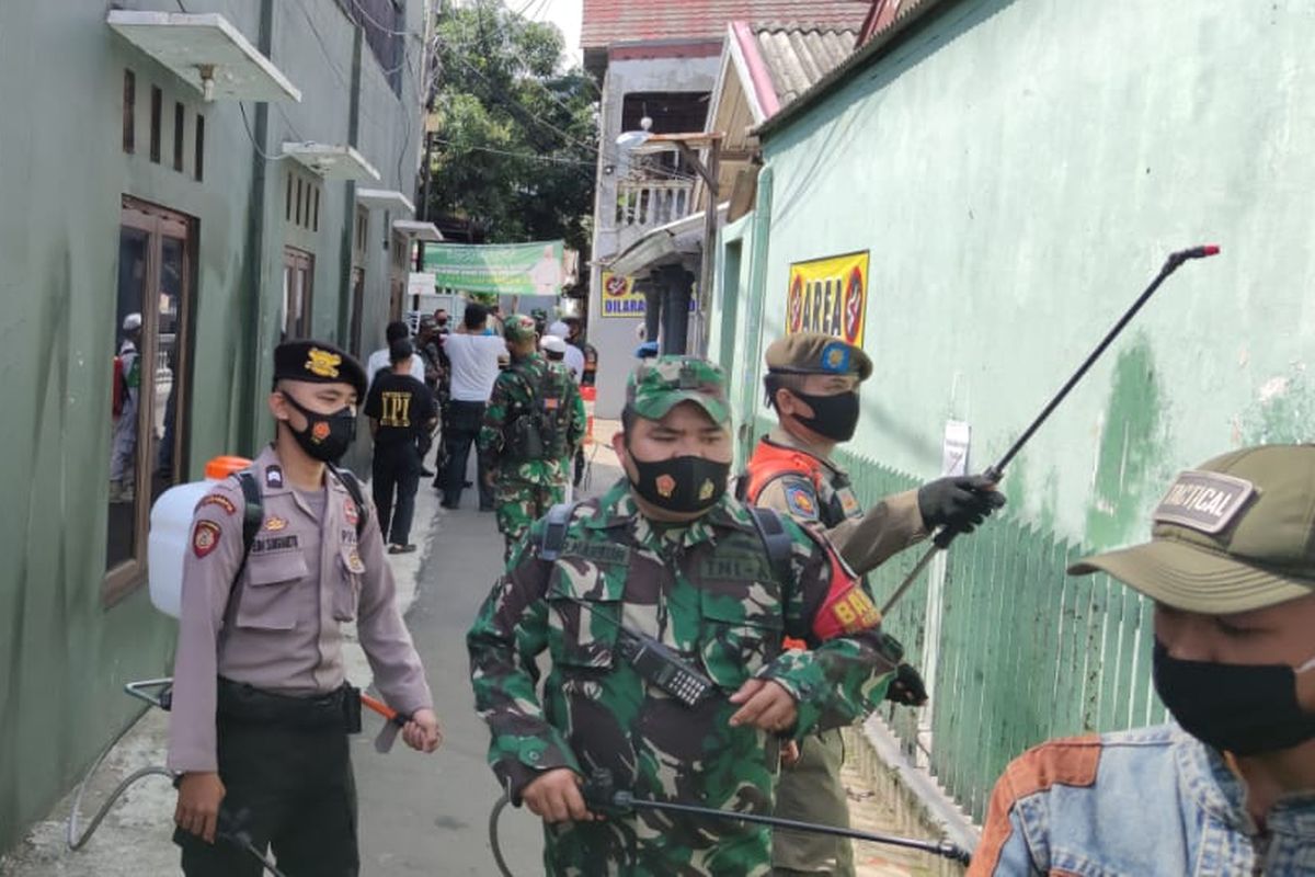 Petugas TNI-Polri dan Satpol PP melakukan penyemprotan di gang rumah Rizieq Shihab di Petamburan, Jumat (27/11/2020)