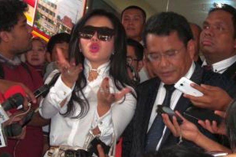 Penyanyi Syahrini didampingi oleh kuasa hukumnya, Hotman Paris Hutapea, menjawab pertanyaan para wartawan seusai menjalani pemeriksaan di Bareskrim Mabes Polri, Jakarta, Senin (2/3/2015). 