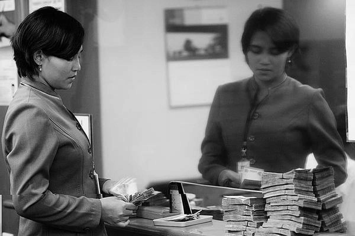 Staf penukaran valuta asing di Kwitang, Jakarta, menghitung mata uang rupiah. 