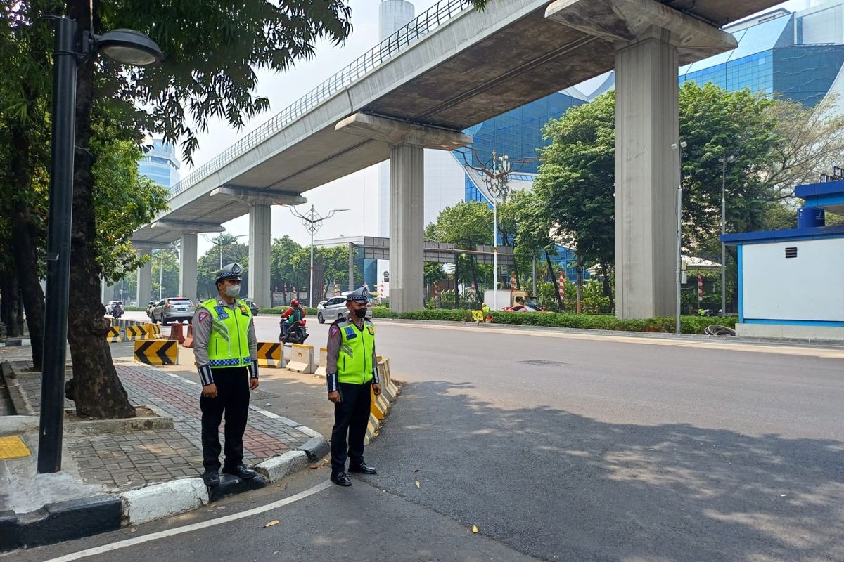 Petugas kepolisian yang berjaga di kawasan Jalan HR Rasuna Said untuk amankan kendaraan pejabat KTT ke-43 ASEAN