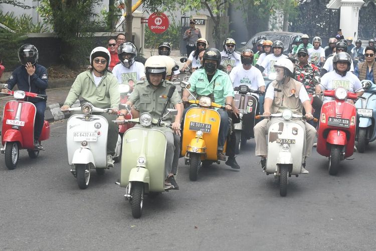 Pasangan bakal calon Wali Kota dan Wakil Wali Kota Palembang Ratu Dewa-Prima Salam berboncengan mengendarai motor Vespa klasik saat mendaftar ke KPU, Kamis (29/8/2024).