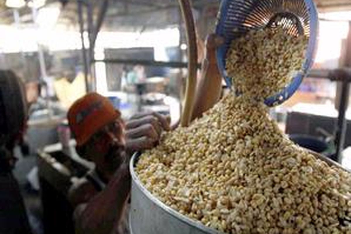 Hakim memasukan kedelai ke dalam mesin penggiling di rumah industri tahu milik H Nurhamid di Jalan Manggis, Kecamatan landasan Ulin, Banjarbaru, Kalsel. Dia masih menggunakan bahan baku kedelai dari Amerika, yang kini harganya berangsur naik hingga mencapai Rp 8.000 per kilogram.