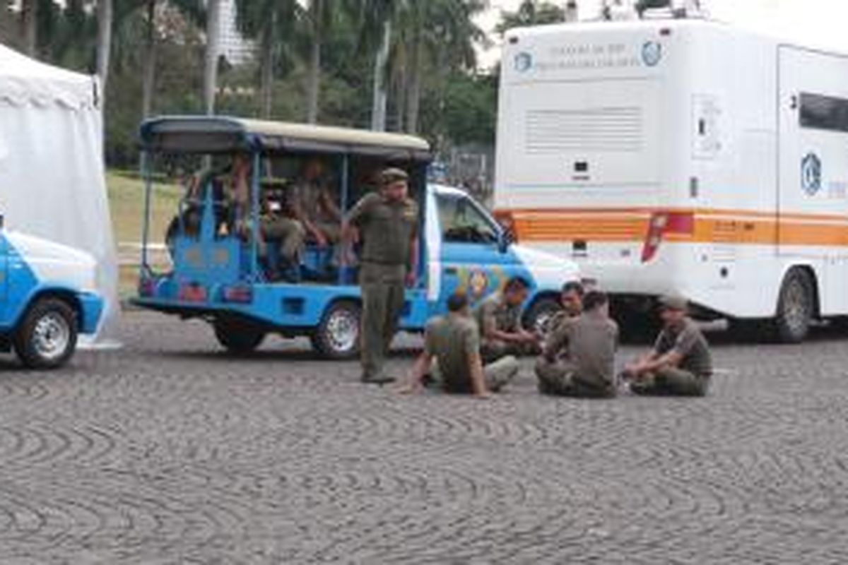Personel Satpol PP hanya duduk-duduk di area Monas, Jakarta Pusat. Padahal banyak pedagang kaki lima (PKL) yang dengan leluasa masuk ke dalam area Monas.