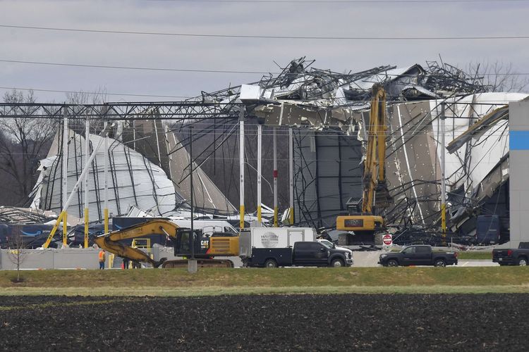 Pekerja membersihkan puing-puing dari gedung Amazon Fulfillment Center yang dilanda badai di Edwardsville, Illinois, Sabtu (12/11/2021).  Badai terkuat dalam sejarah Kentucky dikatakan telah melanda beberapa negara bagian AS dan menghancurkan sedikitnya 70 bangunan, menewaskan sedikitnya 70 orang.