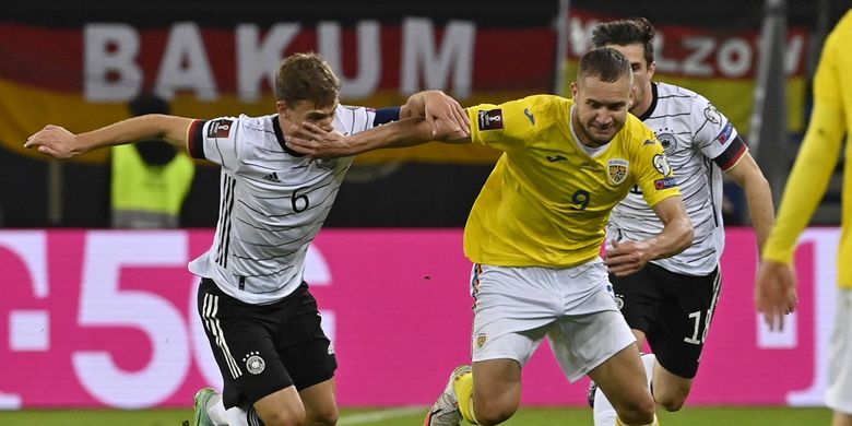 Gelandang timnas Jerman Joshua Kimmich (kiri) berduel dengan penyerang Rumania George Puscas dalam laga lanjutan Kualifikasi Piala Dunia 2022 Zona Eropa di Stadion Volkspark, Sabtu (9/10/2021) dini hari WIB.