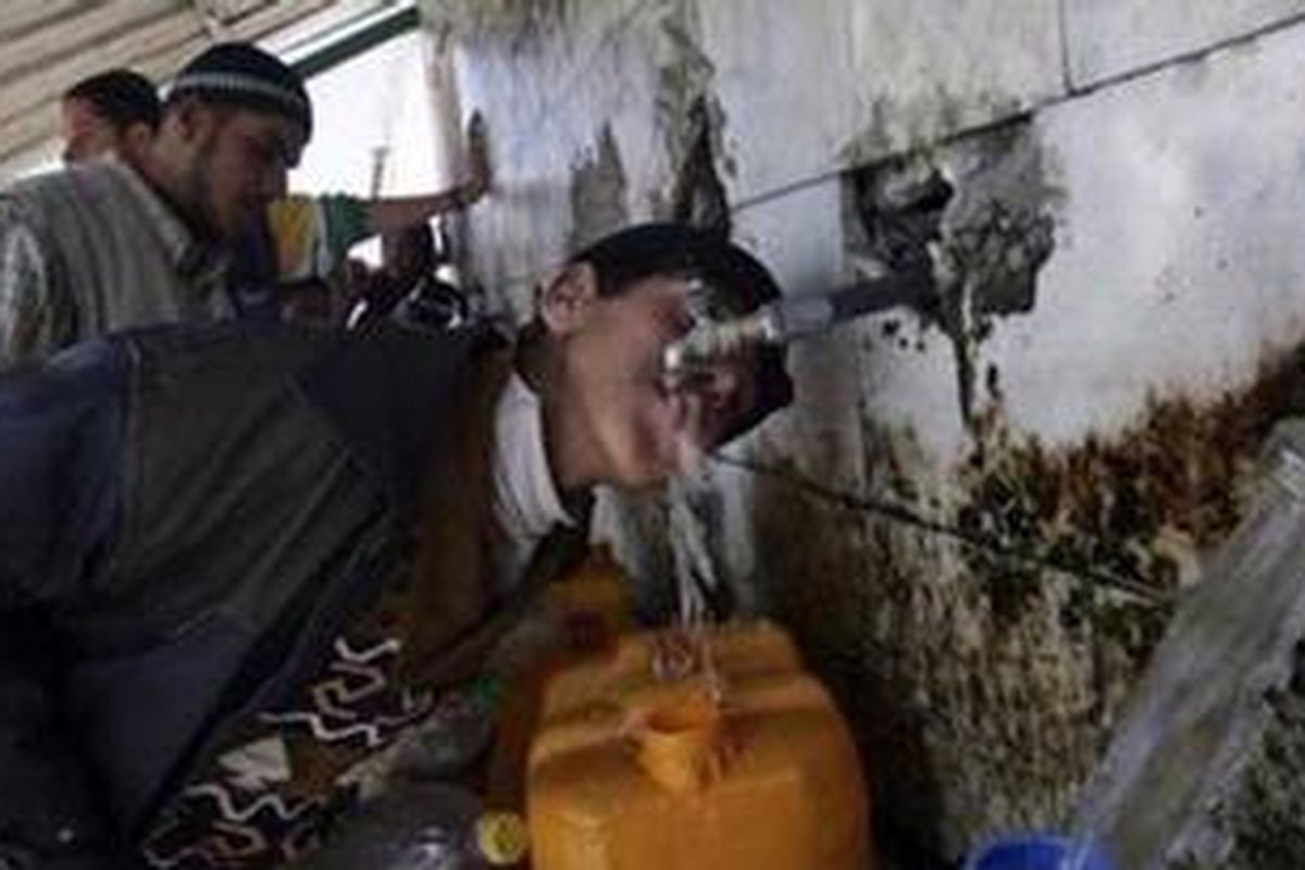 Seorang anak laki-laki meminum air di Khan Younis, Jalur Gaza. Pasokan air bersih menjadi salah satu masalah utama yang dihadapi warga Jalur Gaza.