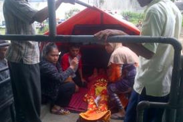 Salah satu warga korban bencana longsor yang selamat dinaikan ke dalam mobil bak terbuka, Senin (15/12/2014). 