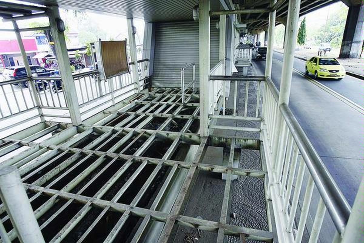 Kendaraan bermotor melintas di samping selter bus transjakarta Bea Cukai yang lantai aluminiumnya raib di Jalan Ahmad Yani, Jakarta Timur, Selasa (29/6). Infrastruktur dan fasilitas penunjang koridor IX dan X mengalami berbagai kerusakan karena tidak dirawat dan tidak digunakan selama tiga tahun.