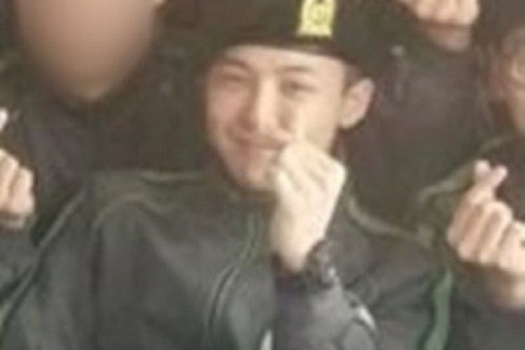 G-Dragon terlihat tersenyum saat sedang berkegiatan di kamp pelatihan militer.