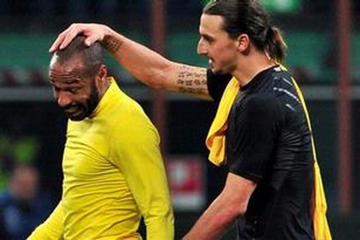 Penyerang AC Milan, Zlatan Ibrahimovic (kanan), dan penyerang Arsenal, Thierry Henry, setelah pertandingan leg pertama 16 besar Liga Champions, di San Siro, Rabu (15/2/2012).