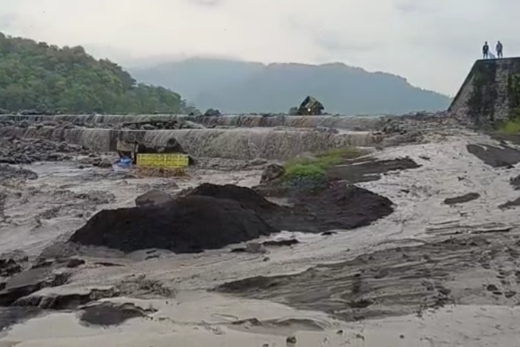Warga hanya bisa melihat dua truk yang terjebak aliran banjir lahar dingin Gunung Semeru di Desa Gondoruso, Kecamatan Pasirian, Kabupaten Lumajang, Selasa (19/4/2022)