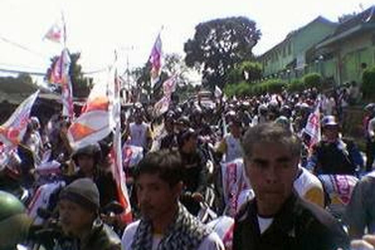 Simpatisan Partai Hanura memenuhi jalan raya di depan lapangan sepak bola caringin, Cicurug, Sukabumi, Jabar, Kamis (26/3). Kampanye terbuka di Sukabumi rencananya akan dihadiri oleh Ketua Umum Partai Hanura Wiranto. 
