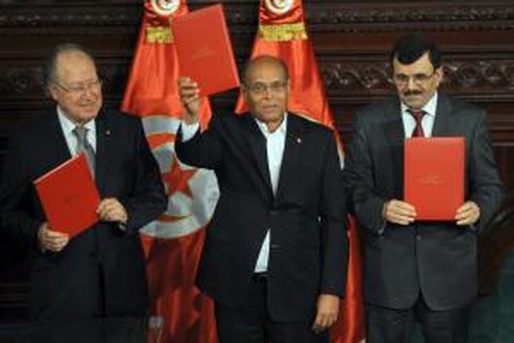 Presiden Tunisia Moncef Marzouki (tengah), perdana menteri yang akan lengser Ali Larayedh (kana), dan ketua parlemen Mustapha ben Jaafar menandatangani kontitusi baru negeri itu pada Senin (27/1/2014), untuk mengakhiri krisis politik di negeri itu.