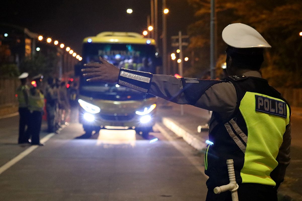 Polisi menghentikan bus untuk diperiksa di akses keluar Jembatan Suramadu, Surabaya, Jawa Timur, Minggu (19/5/2019) dini hari. Kegiatan penyekatan dan razia yang dilakukan Polres Pelabuhan Tanjung Perak Surabaya dibantu oleh personel TNI itu untuk mengantisipasi adanya pergerakan massa ke Jakarta terkait pengumuman hasil pemilihan presiden pada Rabu, 22 Mei 2019 di KPU.